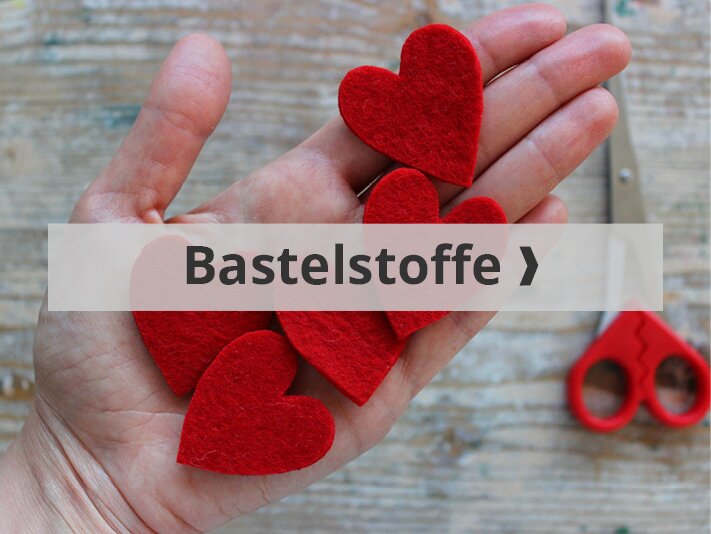 Bastelstoffe Hand mit Herzen und Schere
